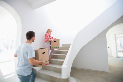 Removal team navigating stairs and access challenges in a North Harrow property